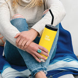 Woman sitting blanket holding Klean Kanteen TKWide insulated bottle with straw cap