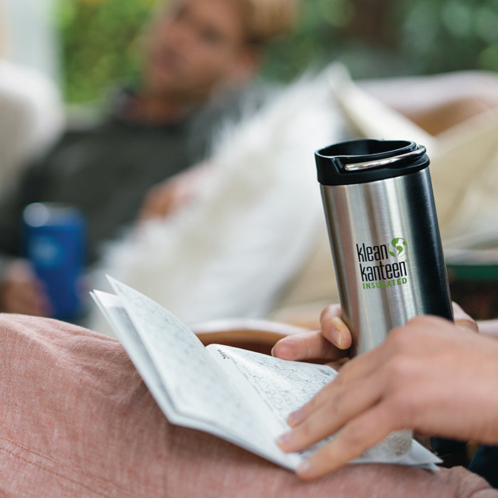 Person holding Klean Kanteen TKWide Insulated bottle resting on couch