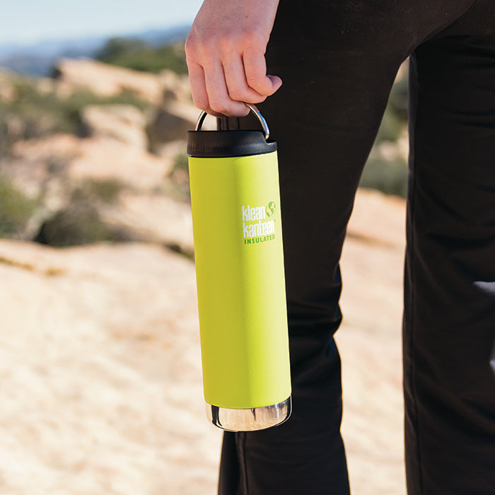 Man standing on ridge line holding Klean Kanteen TKWide insulated bottle 