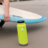 Klean Kanteen TKWide insulated bottle with loop cap standing up in sand at beach
